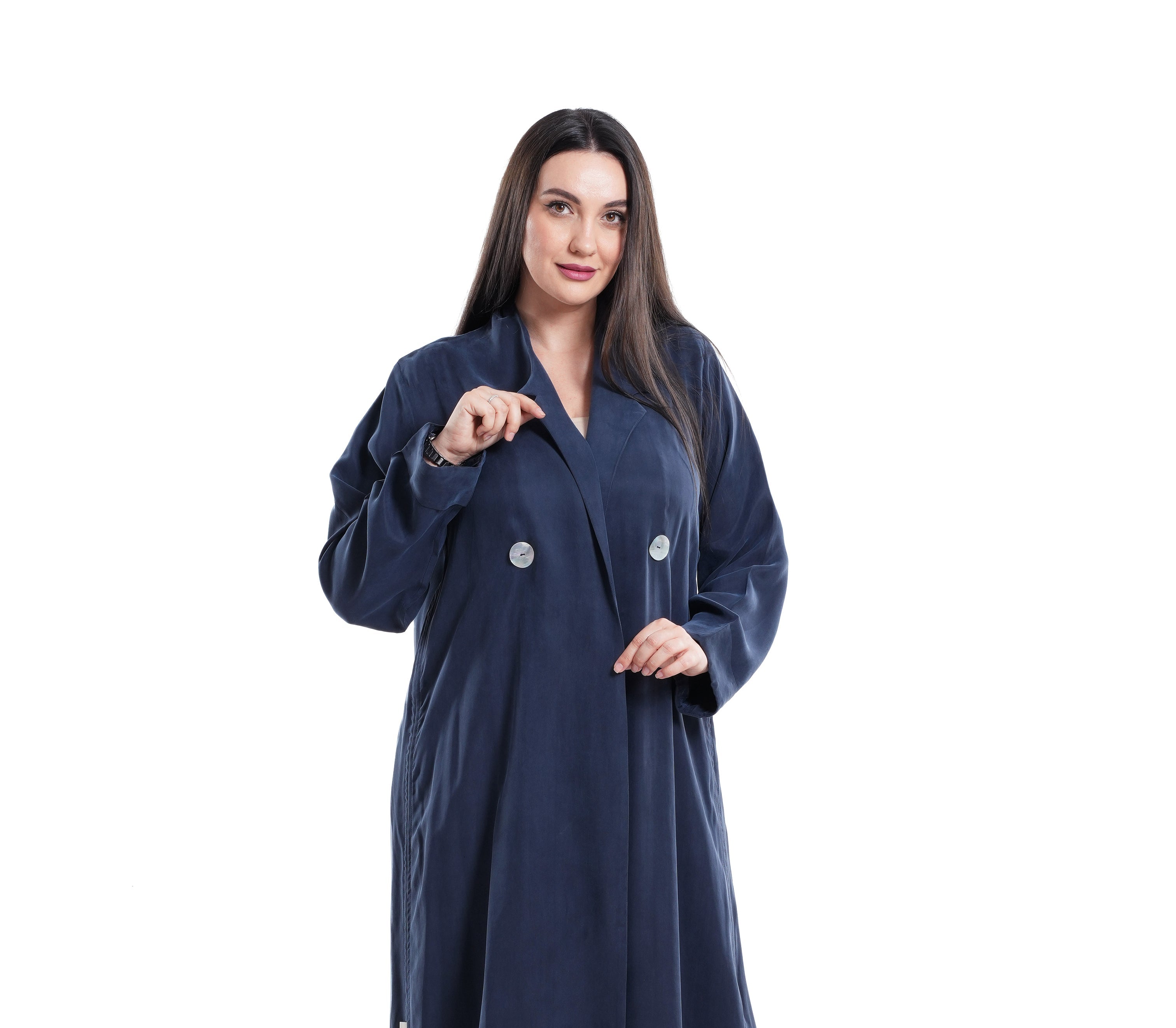 Woman wearing a long navy blue coat on a white background