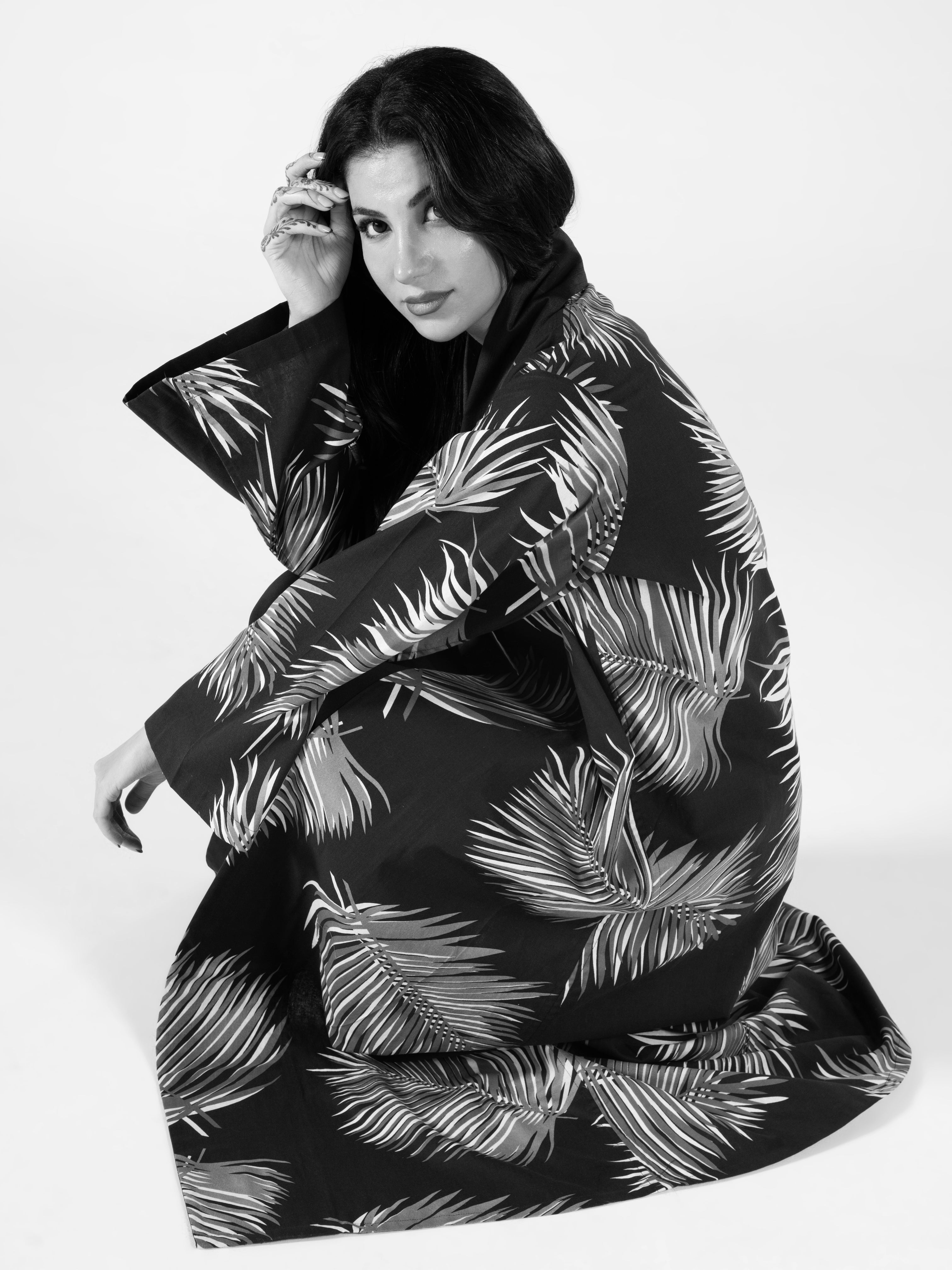 Person wearing a black and white patterned coat on a white background